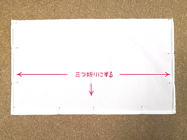 エプロンの端を三つ折りにする